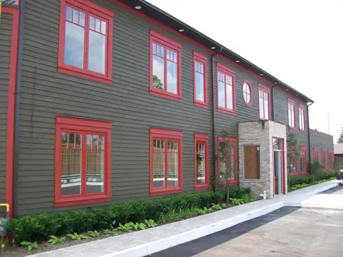 red casement macfarlane (1) A large dark brown building with striking red framed casement windows, a fantastic project from MacFarlane Windows and Doors showing their casement window styles.